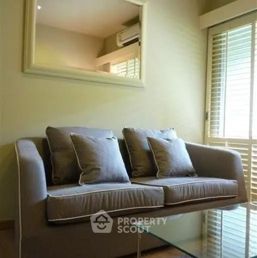 Cozy living room with plush sofa and large mirror, perfect for relaxation.