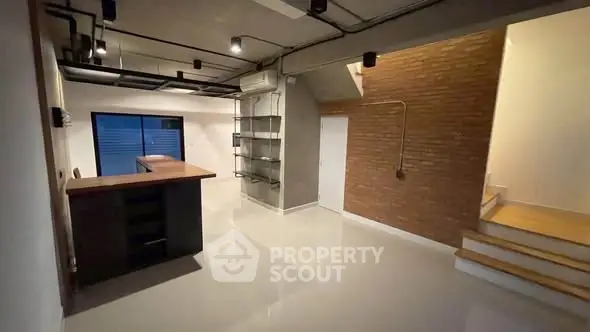 Modern industrial-style interior with open layout and brick accent wall