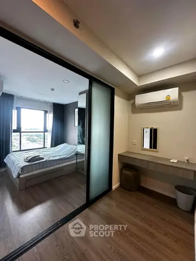 Modern bedroom with sliding glass door and air conditioning, featuring a cozy bed and stylish decor.