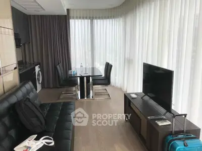 Modern living room with sleek furniture and large windows offering natural light.