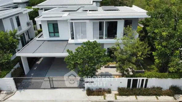 Modern luxury home with sleek design and spacious driveway in a serene neighborhood.