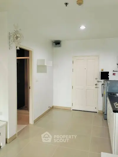 Modern kitchen with sleek design and white cabinetry in a cozy apartment setting.