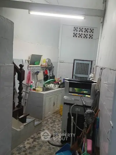 Compact kitchen with washing machine and tiled flooring in cozy home