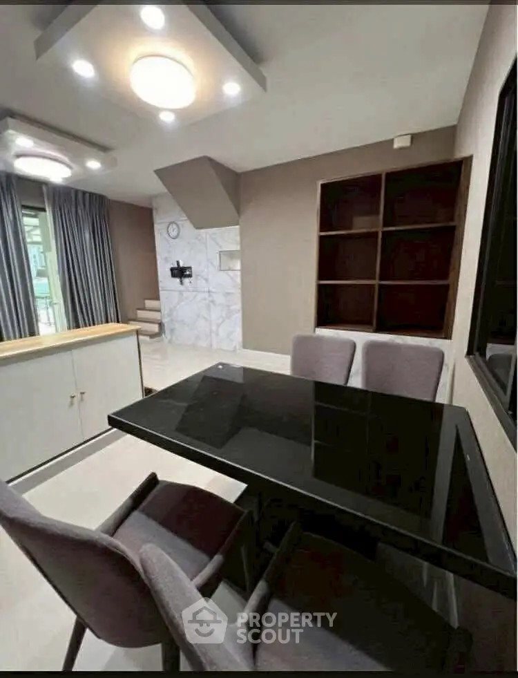 Modern dining area with sleek black table and elegant chairs in a stylish apartment.