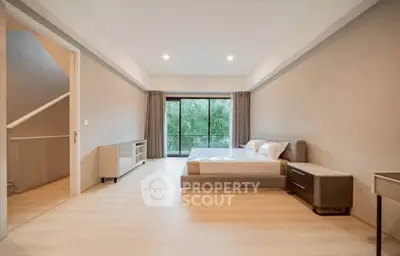 Spacious modern bedroom with large windows and serene view, perfect for relaxation and comfort.
