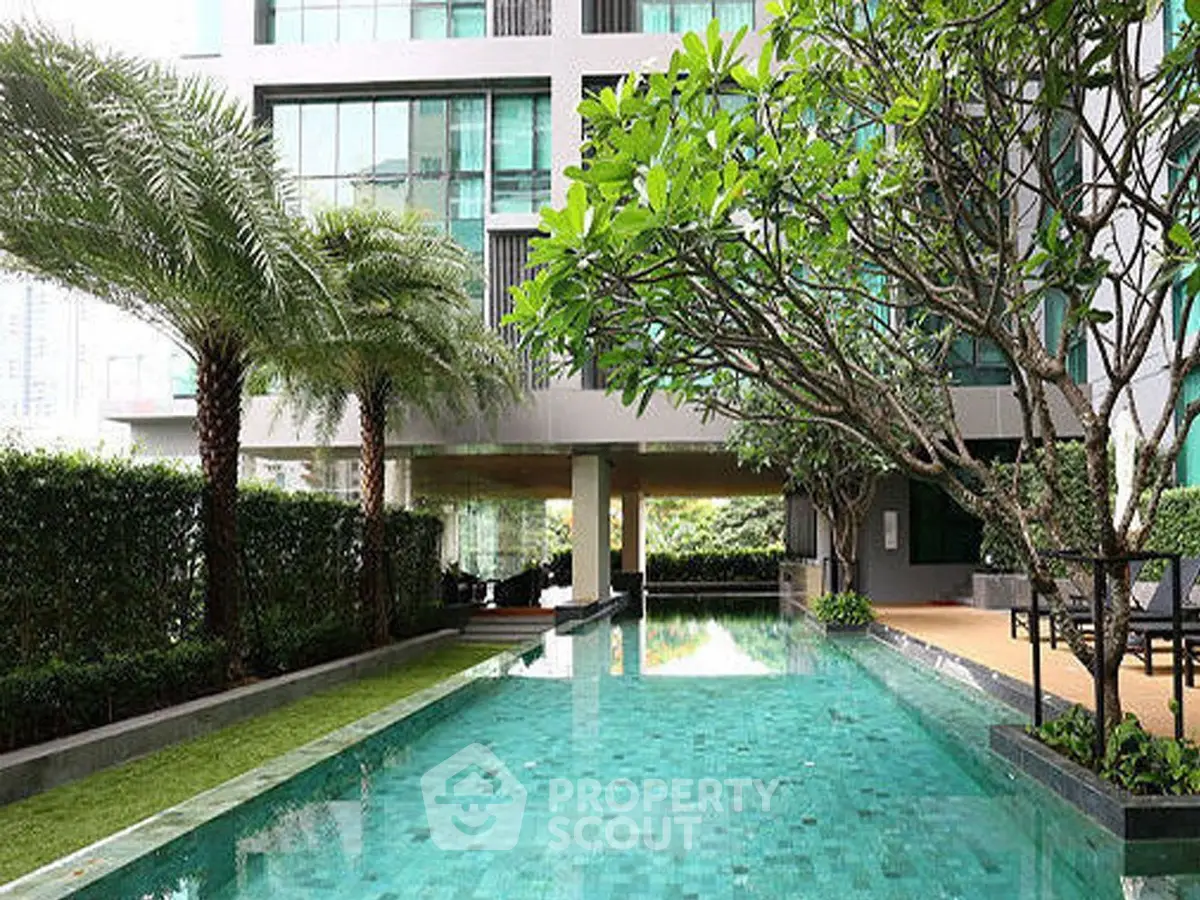 Luxurious condominium with stunning pool and lush greenery in urban setting.