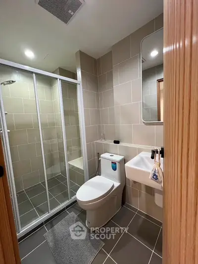 Modern bathroom with glass shower enclosure and sleek fixtures
