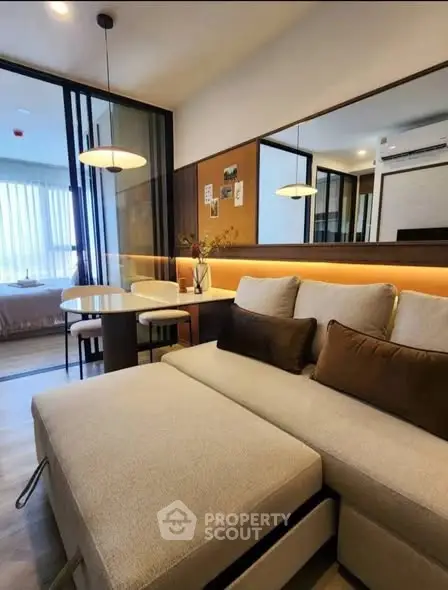 Modern living room with cozy sofa and dining area in open layout apartment.