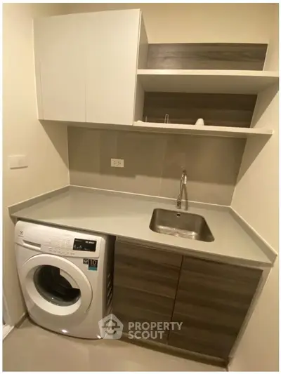 Modern laundry room with washing machine and sleek cabinetry