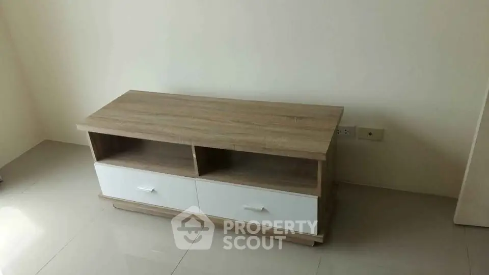 Modern wooden TV stand with storage drawers in minimalist living room.