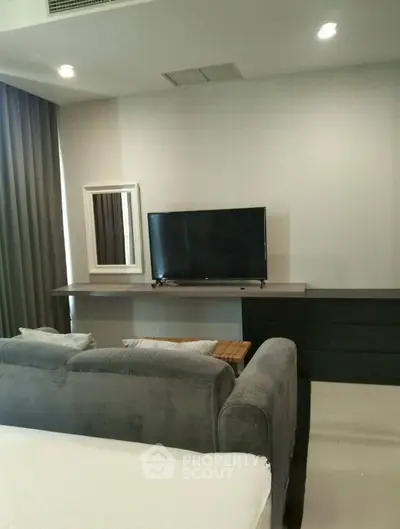 Modern living room with sleek TV setup and cozy gray sofa