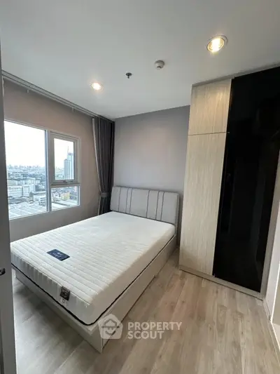 Modern bedroom with city view, featuring a sleek wardrobe and cozy bed setup.