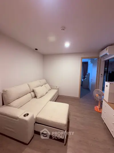 Cozy living room with modern sofa and wooden flooring in a stylish apartment.