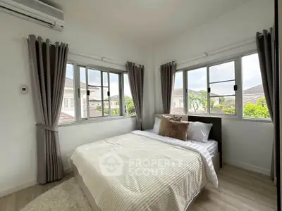 Bright and cozy bedroom with large windows and modern decor in a stylish home.