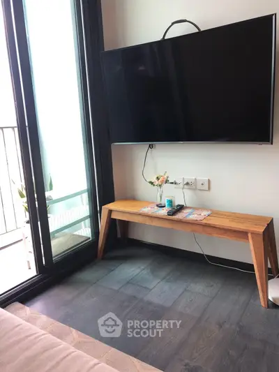 Modern living room with sleek TV setup and balcony access