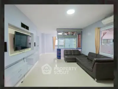 Spacious living room with modern decor and wall-mounted TV