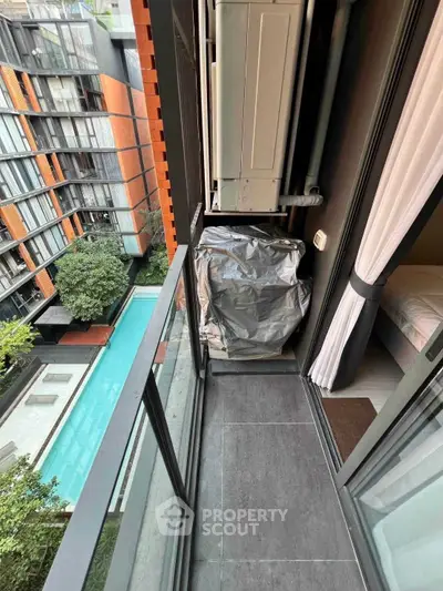 Modern apartment balcony with pool view and air conditioning unit, ideal for urban living.