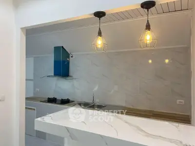 Modern kitchen with marble countertop and stylish pendant lights