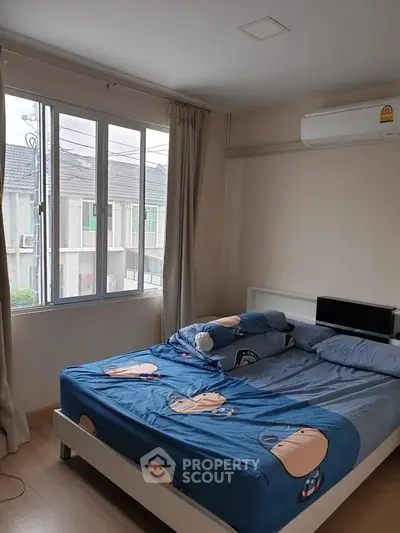Cozy bedroom with large window and air conditioning in modern apartment
