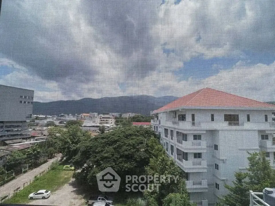 Stunning cityscape view from a high-rise apartment showcasing urban living with mountain backdrop.