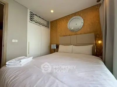 Luxurious bedroom with elegant decor and plush bedding in modern apartment.