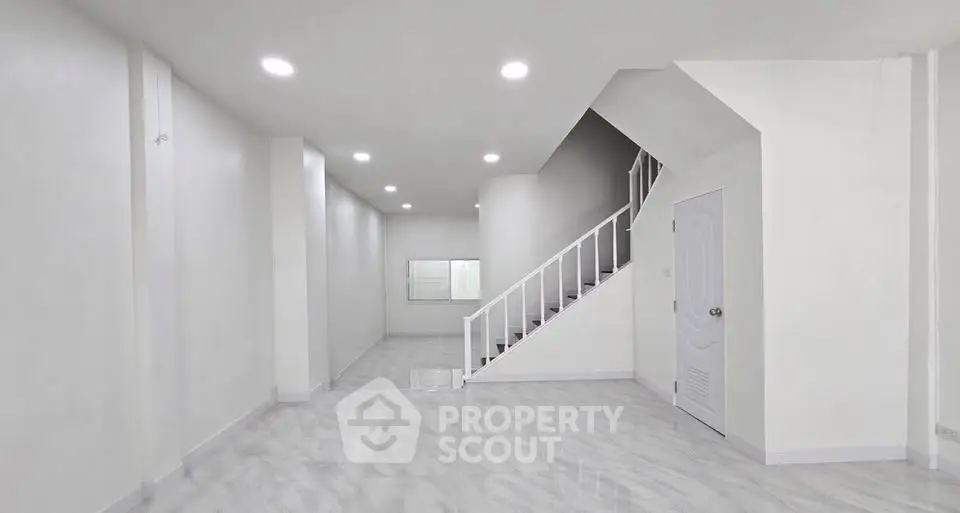 Spacious modern interior with sleek staircase and bright lighting, perfect for contemporary living.