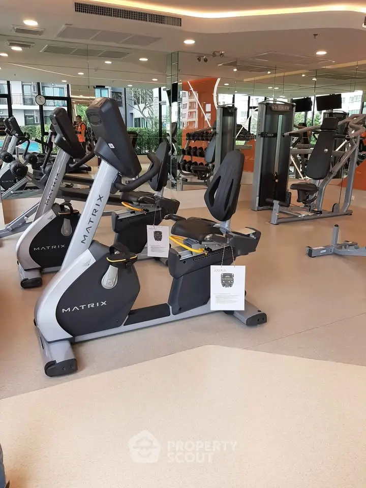 Modern gym with state-of-the-art exercise equipment and mirrored walls in a luxury residential building.