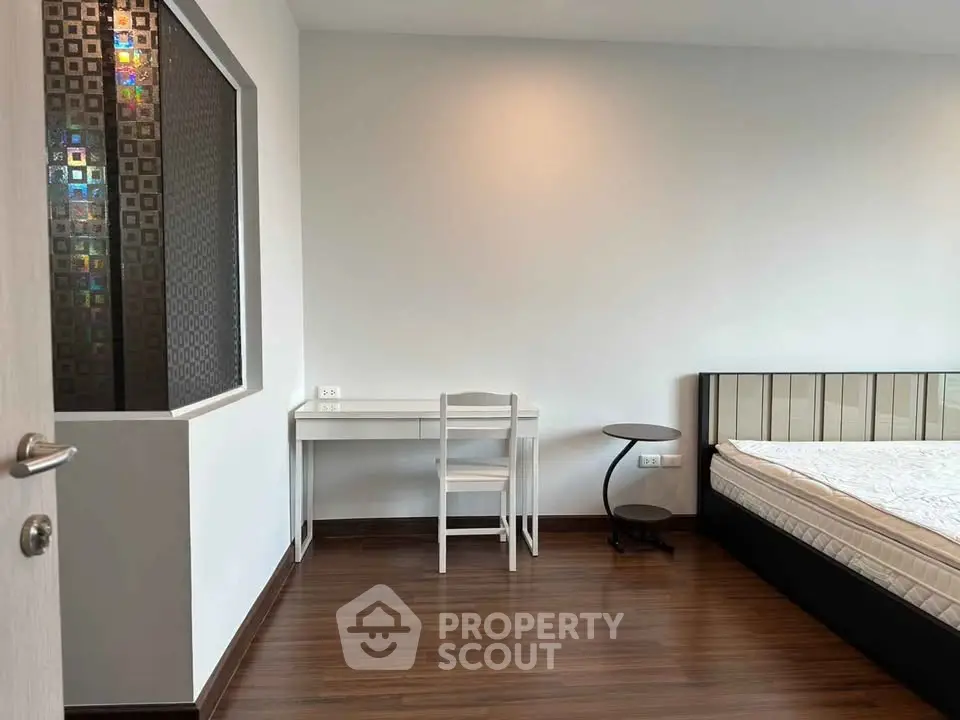 Modern bedroom with sleek wooden flooring and minimalist furniture design.