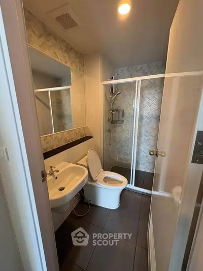 Modern bathroom with glass shower and sleek fixtures in a contemporary apartment.