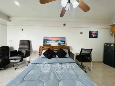 Cozy bedroom with modern decor, featuring a comfortable bed, office chair, and ceiling fan.