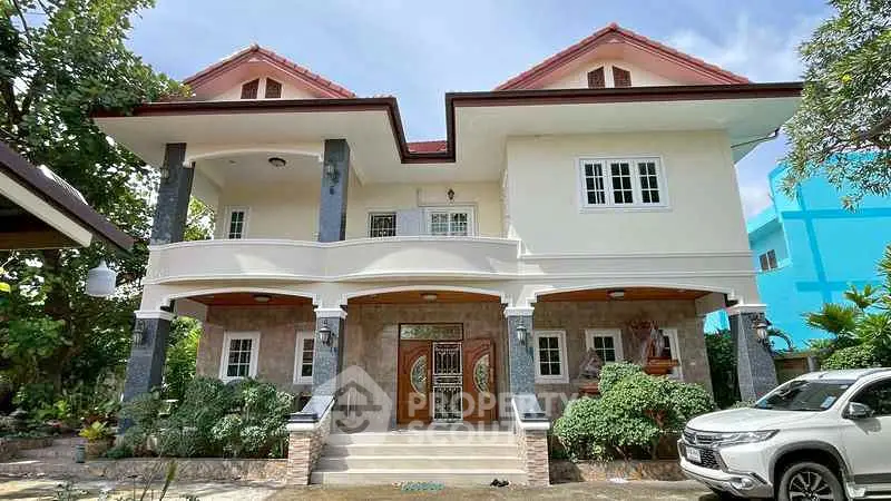 Stunning two-story house with lush garden and elegant entrance in a serene neighborhood.