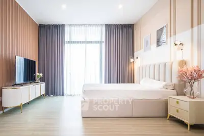 Luxurious modern bedroom with elegant decor and large windows for natural light.