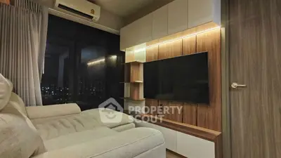 Modern living room with sleek TV unit and cozy seating area, perfect for relaxation.