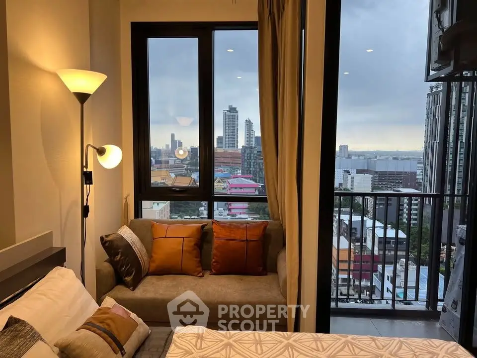 Chic bedroom with cozy sofa and stunning city view from balcony