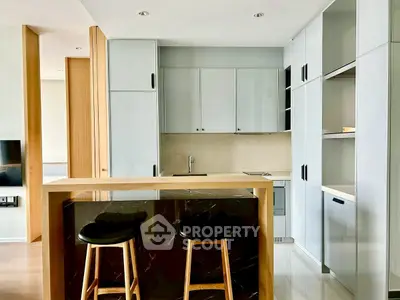 Modern kitchen with sleek cabinetry and breakfast bar in stylish apartment.
