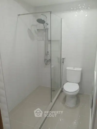 Modern bathroom with glass shower enclosure and sleek white fixtures.