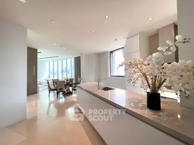 Luxurious open-plan kitchen and dining area with elegant decor and natural light.
