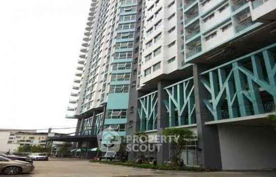 Modern high-rise residential building with unique architectural design and ample parking space.
