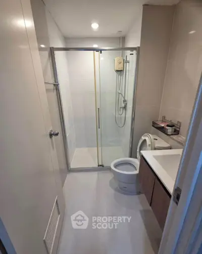 Modern bathroom with glass shower and sleek fixtures in a contemporary apartment.