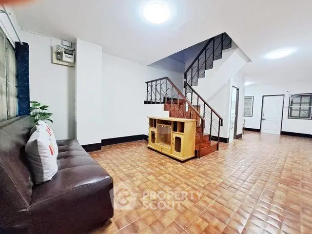 Spacious living room with wooden staircase and modern decor