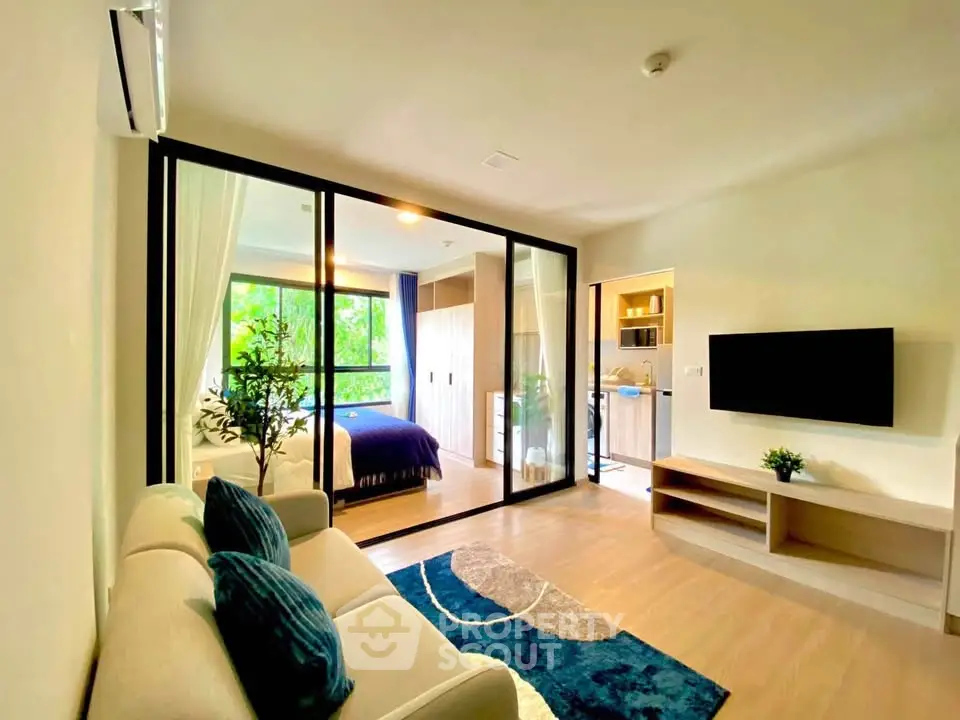 Modern living room with open layout and stylish decor, featuring a cozy sofa and large window view.
