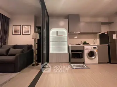 Modern open-plan living room and kitchen with sleek appliances and stylish decor.