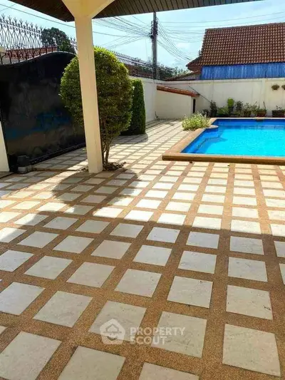 Spacious outdoor area with a stunning pool and tiled patio, perfect for relaxation and entertainment.