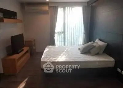 Modern bedroom with sleek design, featuring a large window and stylish furniture, perfect for urban living.