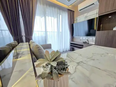 Modern living room with marble table, large TV, and elegant curtains