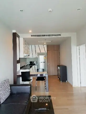 Modern open-layout kitchen and living area with sleek design and wooden flooring.