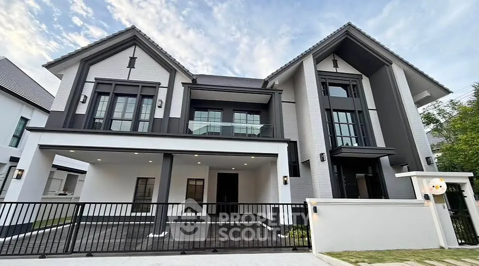 Stunning modern two-story house with sleek design and spacious driveway, perfect for luxurious living.