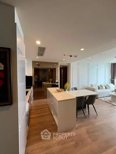 Modern open-plan kitchen and living room with sleek design and cozy ambiance.