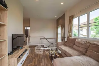 Spacious living room with cozy sectional sofa and modern entertainment center, featuring large windows for natural light.