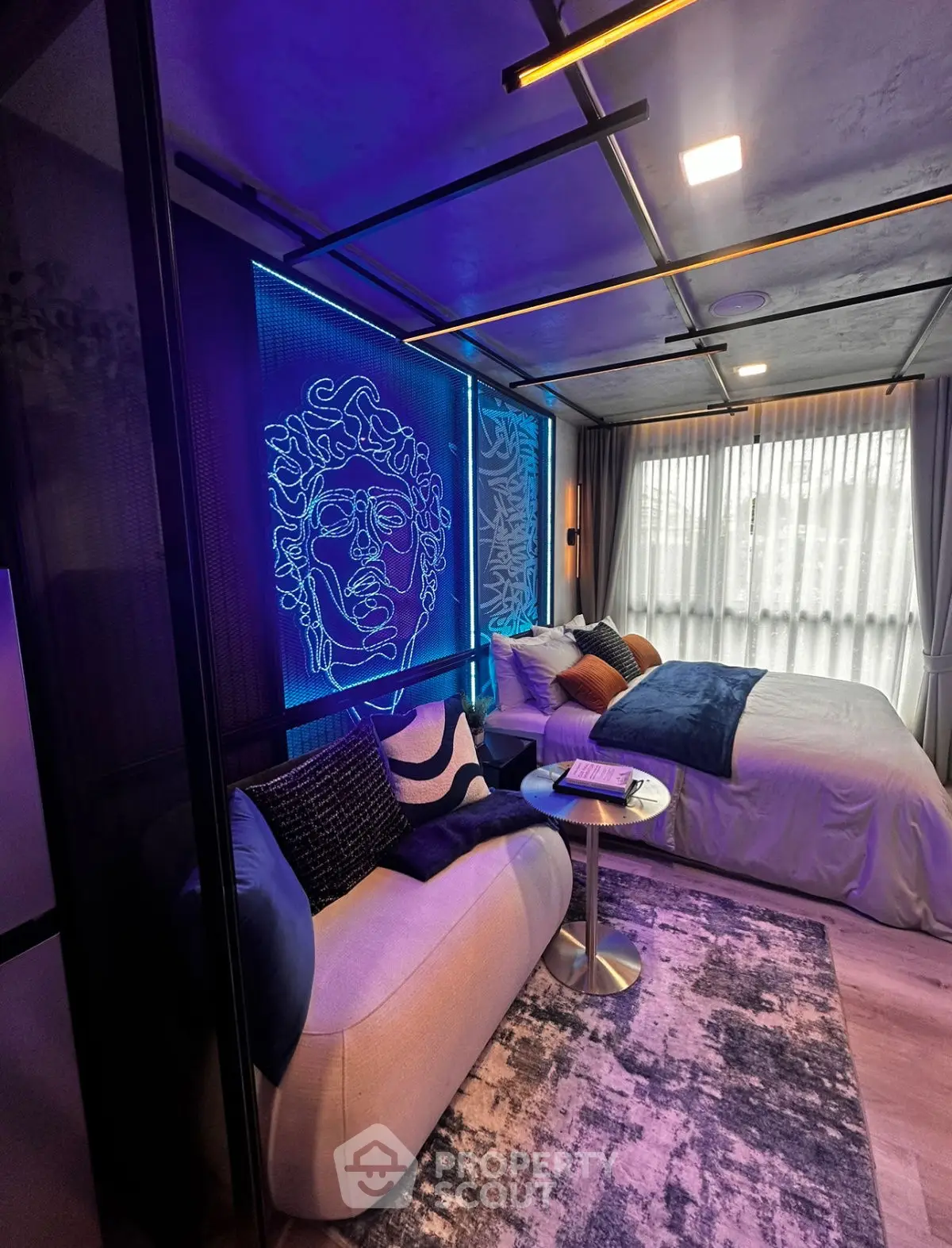 Modern studio apartment with stylish neon art and cozy furnishings